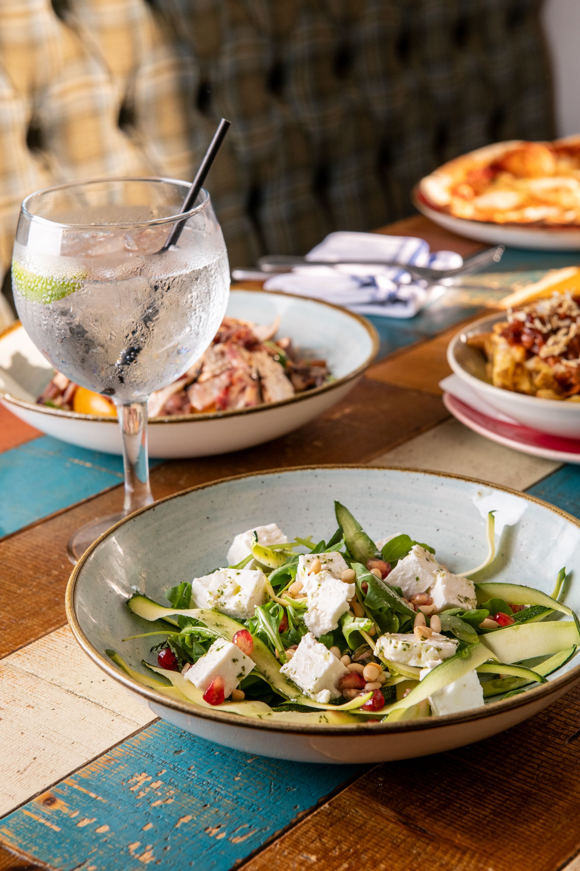 Feta salad with gin and tonic and other dishes on table